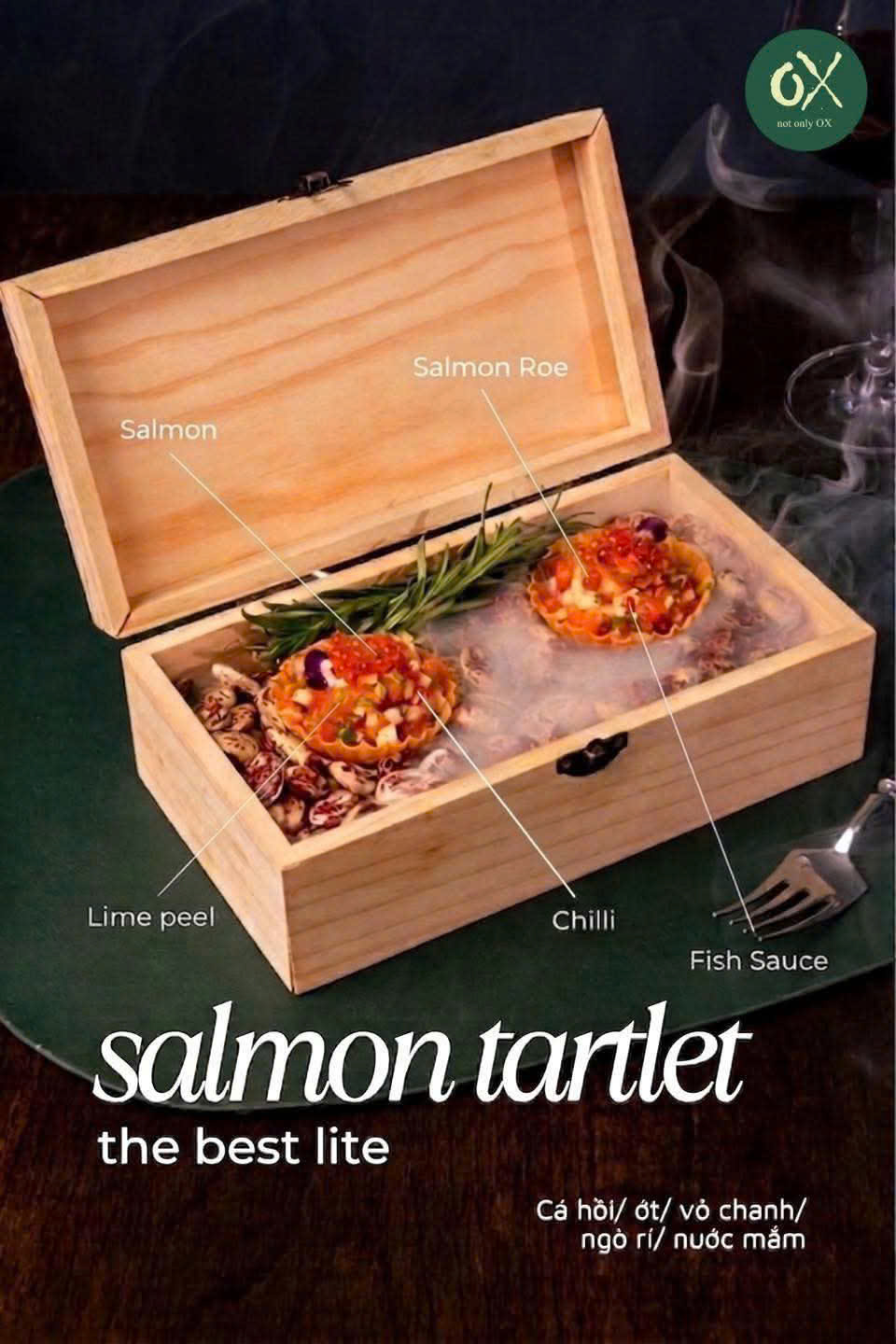 Two salmon tartlets with roe in a wooden box, with the restaurant’s printed title